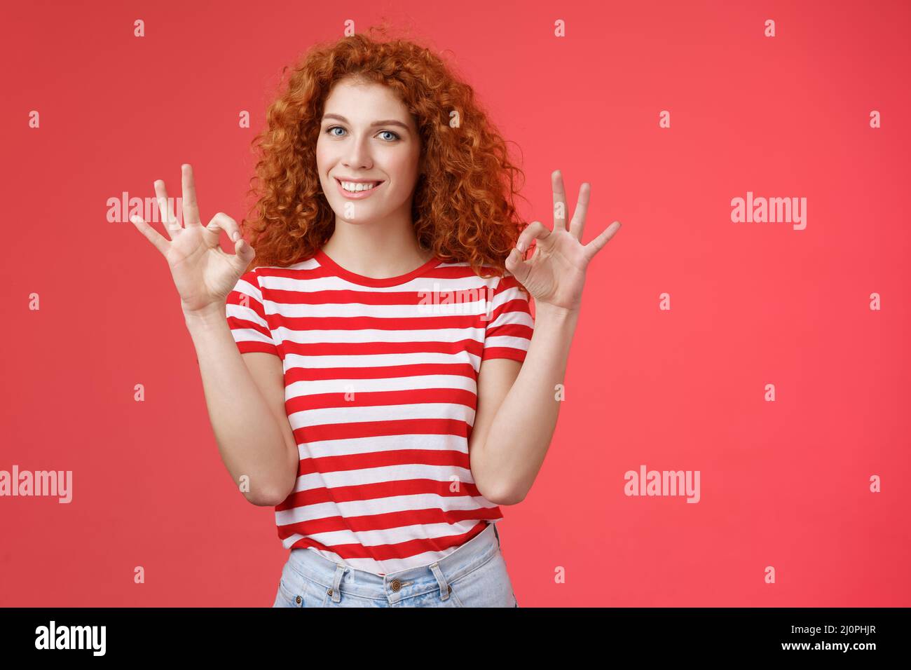 Fine relax everything perfect. Satisfied good-looking redhead cheerful sassy girlfriend curly haristyle show okay ok confirm ges Stock Photo
