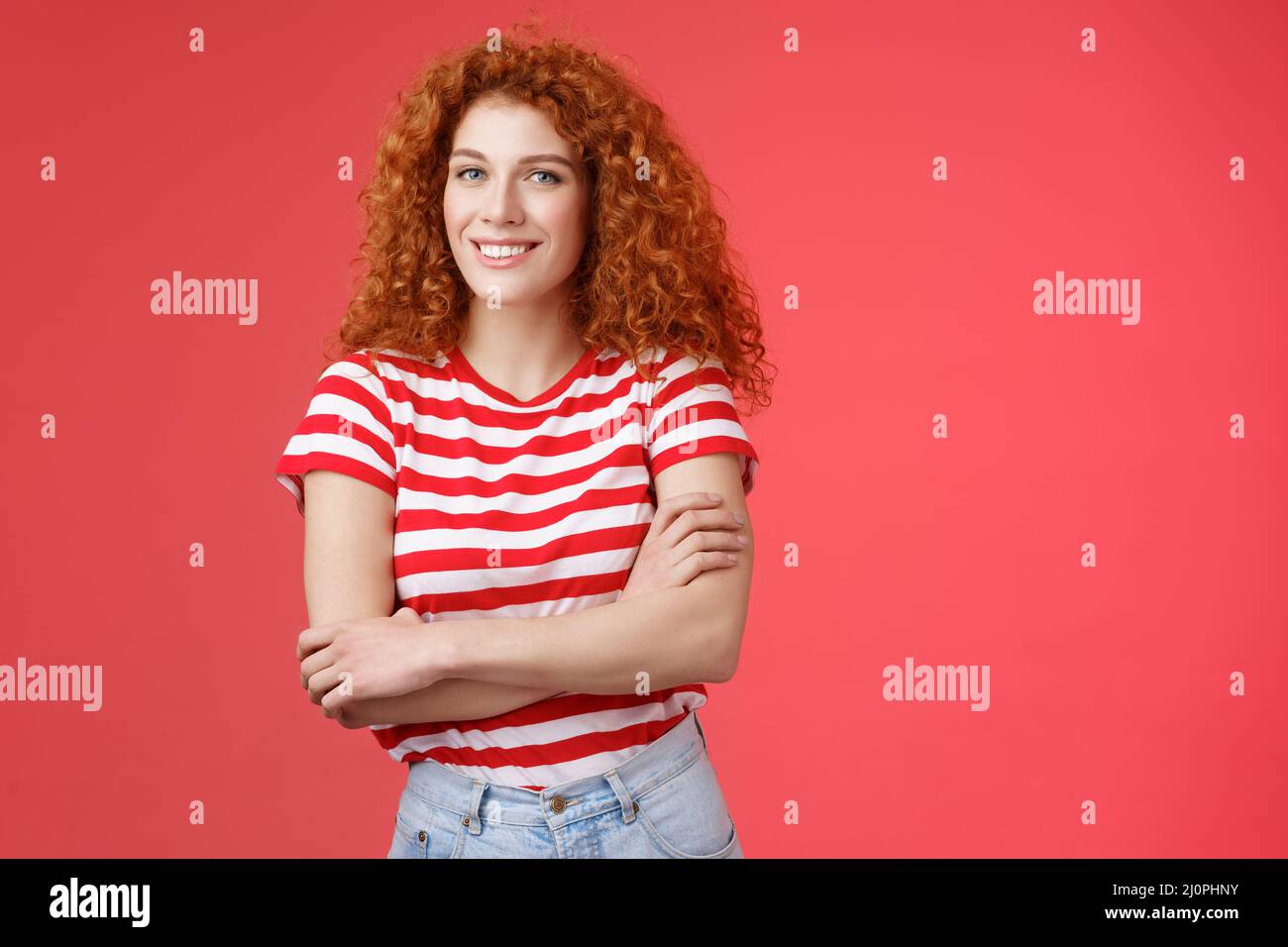 Confident tender silly redhead beautiful curly-haired girl cross arms body smiling broadly delighted amused cheerfully enjoy war Stock Photo