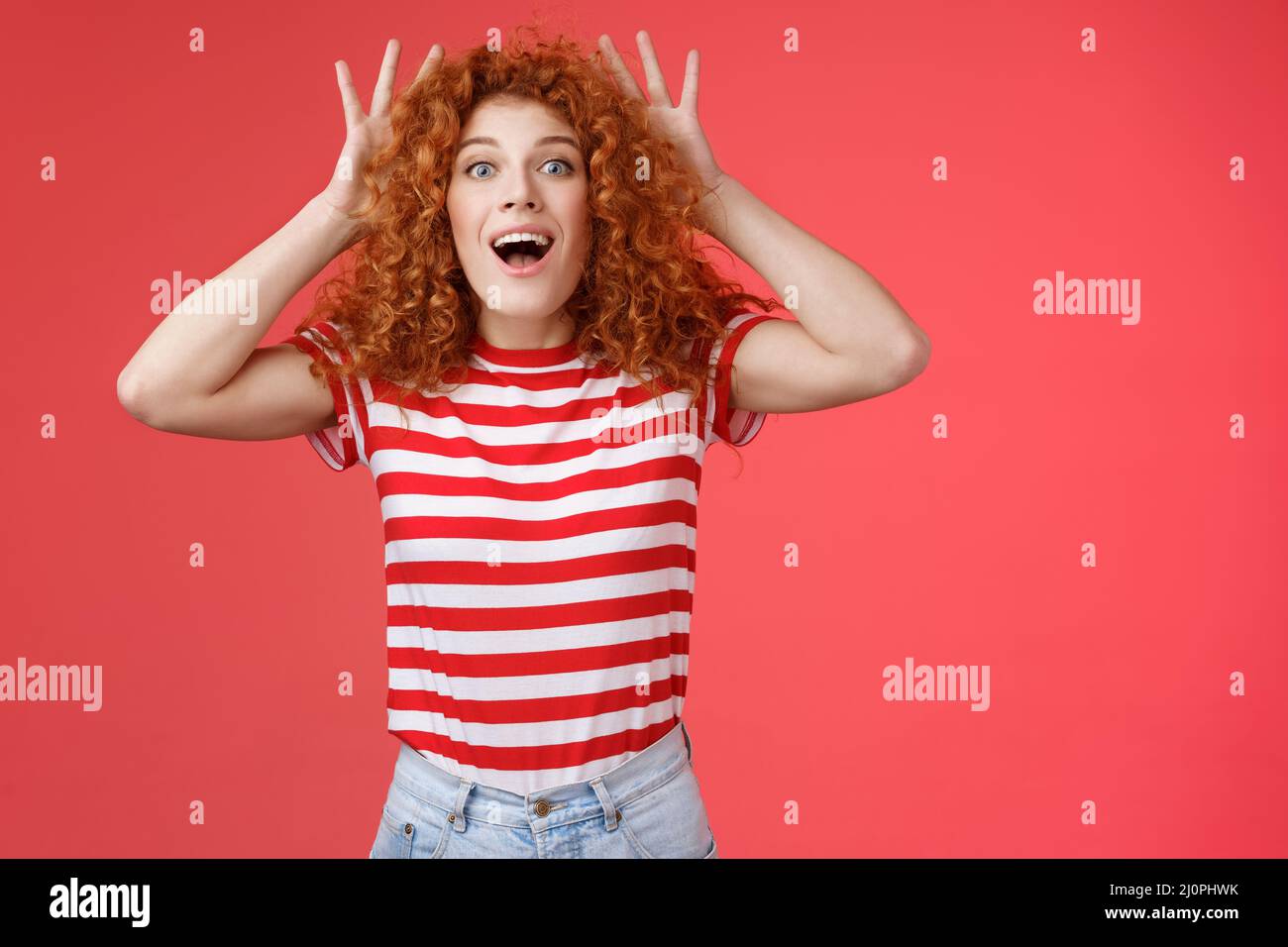 Impressed excited shocked young cute redhead curly-haired ginger girlfriend reacting amazed surprised awesome gift cannot believ Stock Photo