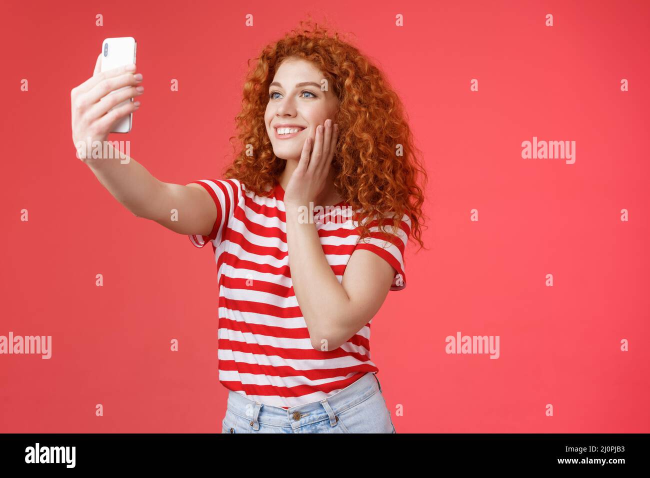 Stylish social media female popular lifestyle blogger adore taking photos herself extend arm hold smartphone posing silly cute s Stock Photo