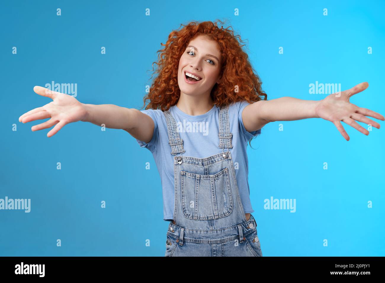 Friendly cheerful family-oriented stylish charming redhead curly-haired girl extend arms embraces wanna cuddle smiling tender ti Stock Photo