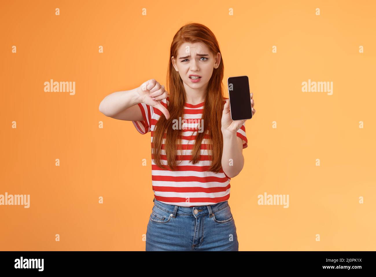 Disappointed picky female disapprove awful bad app, hold smartphone ...