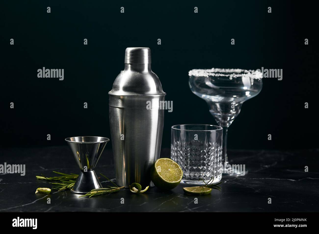 Cocktail shaker and cocktail glasses, and ingredients on dark marble background Stock Photo