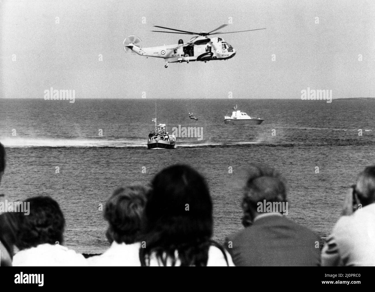 A RAF search and rescue Sea King helicopter from RAF Boulmer and a RNLI lifeboat give a demonstration for the crowds at the Seahouses RNLI Fete.   29/08/1983 Stock Photo