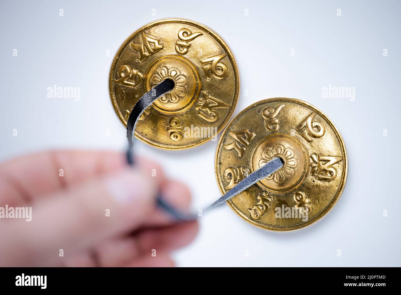 A person holding a Tingsha Cymbals or Mane Padme Hum Symbols Embossed Hand Tuned from Nepal Stock Photo