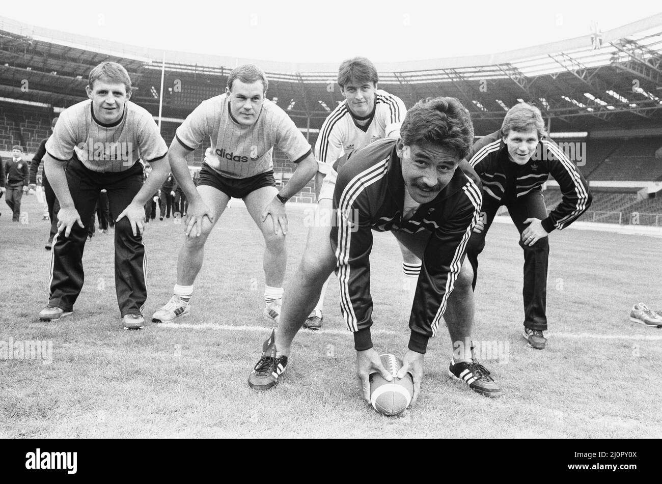 Trying Rugby the Ameriacn Way are Widnes players, front Kevin Tamati, Back left to right Andy Gregory, Mike O'Neill, Joe Lydon and John Bassnett, as they prepare on the Wembley pitch for the upcoming Rugby League Cup Final against Wigan. 5th May 1984 Stock Photo