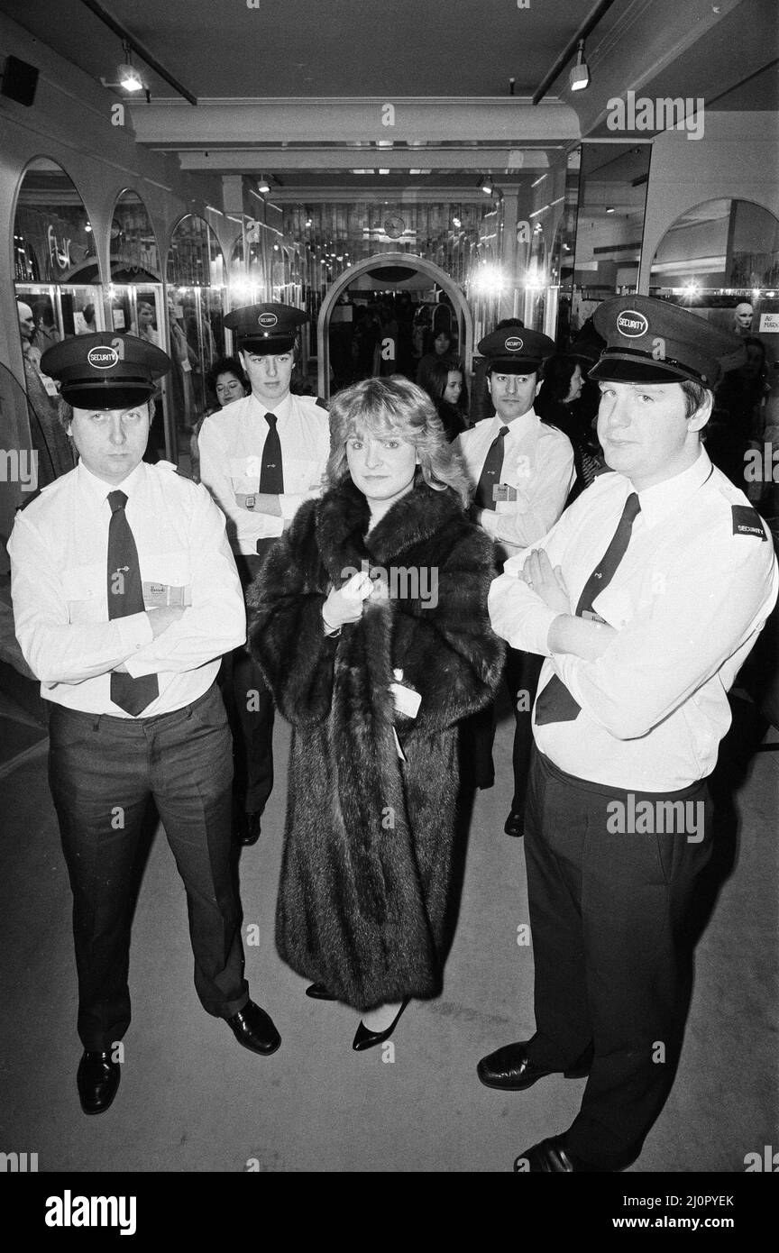 Harrods sale gets underway in Knightsbridge, London. Sara Ford wearing the £55,000 Sable fur coat from Russia, reduced to £33,000, under the watchful eye of the security men . 7th January 1983. Stock Photo