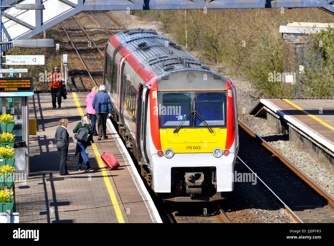 Pontyclun, Wales - March 2022:  People getting on and off a train operated by Transport for Wales at the railway station in the village of Pontyclun Stock Photo