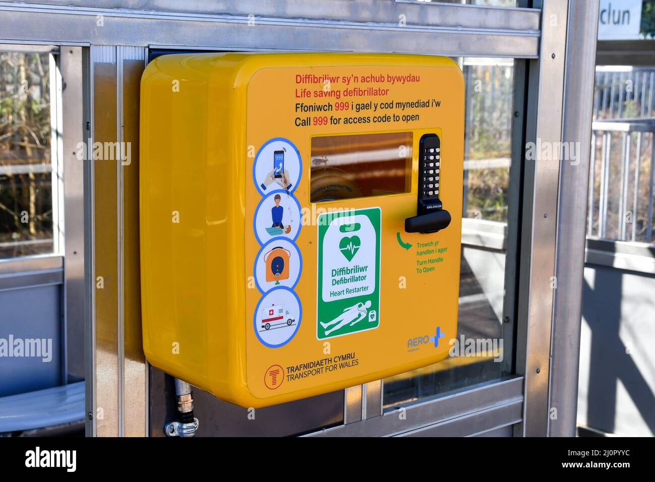 Pontyclun, Wales - March 2022:  Close up of a defibrillator heart restarter in a locked case on the platform of the village's railway station. Stock Photo