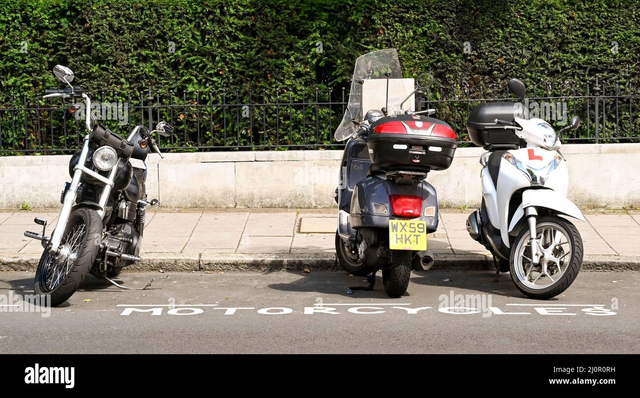 London, England - August 2021: Row of motorbikes and scooters parked in a dedicated parking bay on a street in central London Stock Photo
