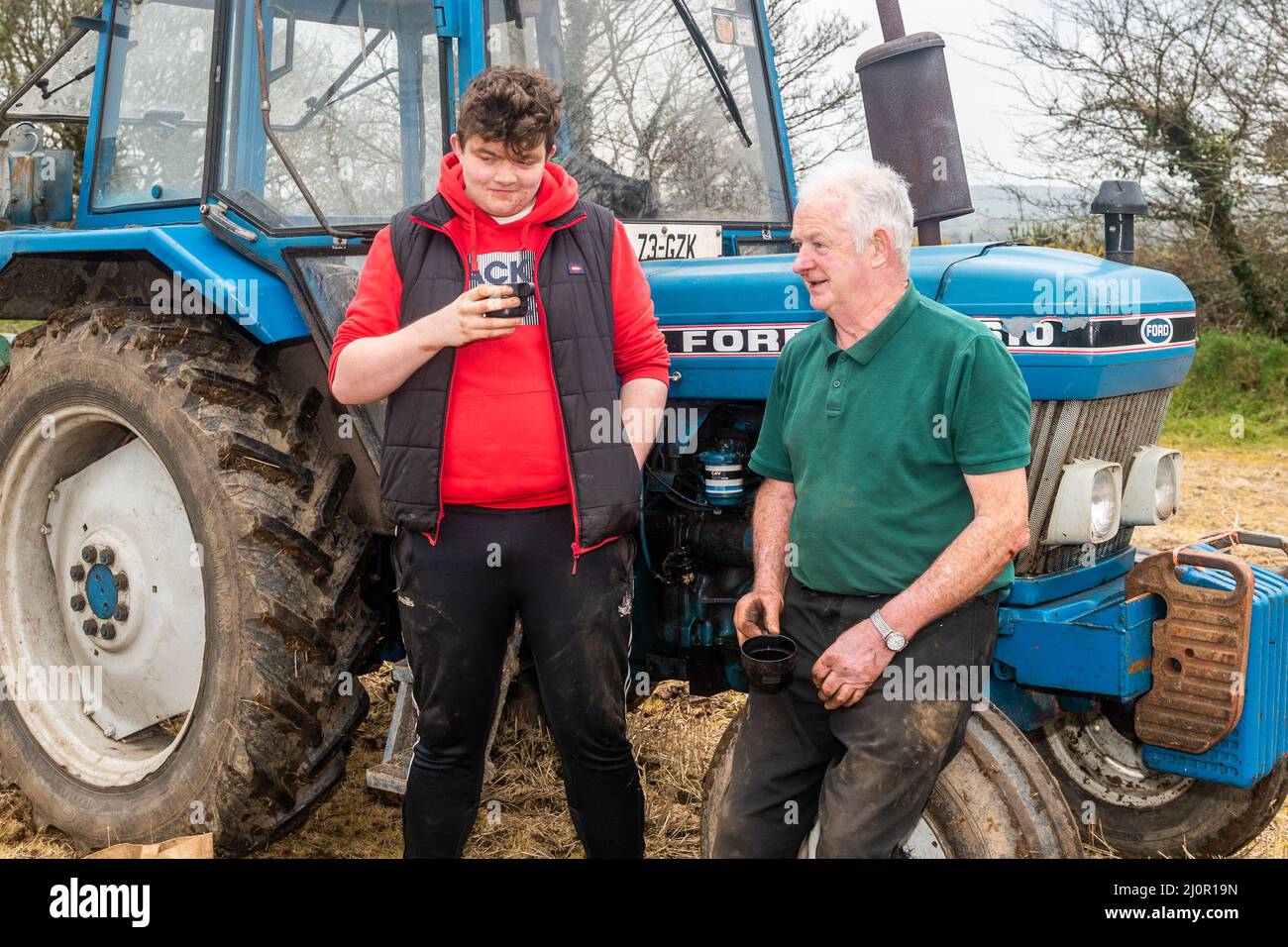 Kilmeen, West Cork, Ireland. 20th Mar, 2022. A ploughing match took place today on the lands of John and Declan Buttimer, Rossmore. A large number of competitors took part in what is the penultimate ploughing match of the season with the Kilbrittain match next weekend. Having a cup of tea before the match commenced were Eugene O'Donovan and his grandfather John, from Roosmore. Credit: AG News/Alamy Live News Stock Photo