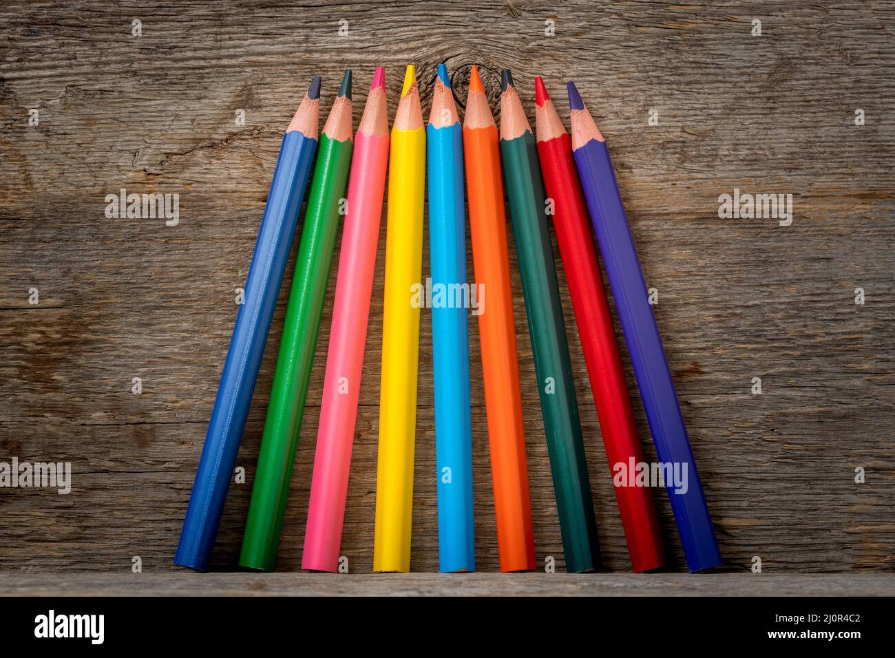 Colored pencil crayons standing on the shelf Stock Photo