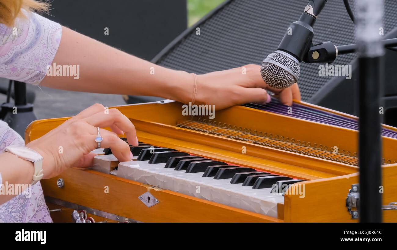 Woman hands playing Indian classical harmonium keyboard: close up Stock Photo