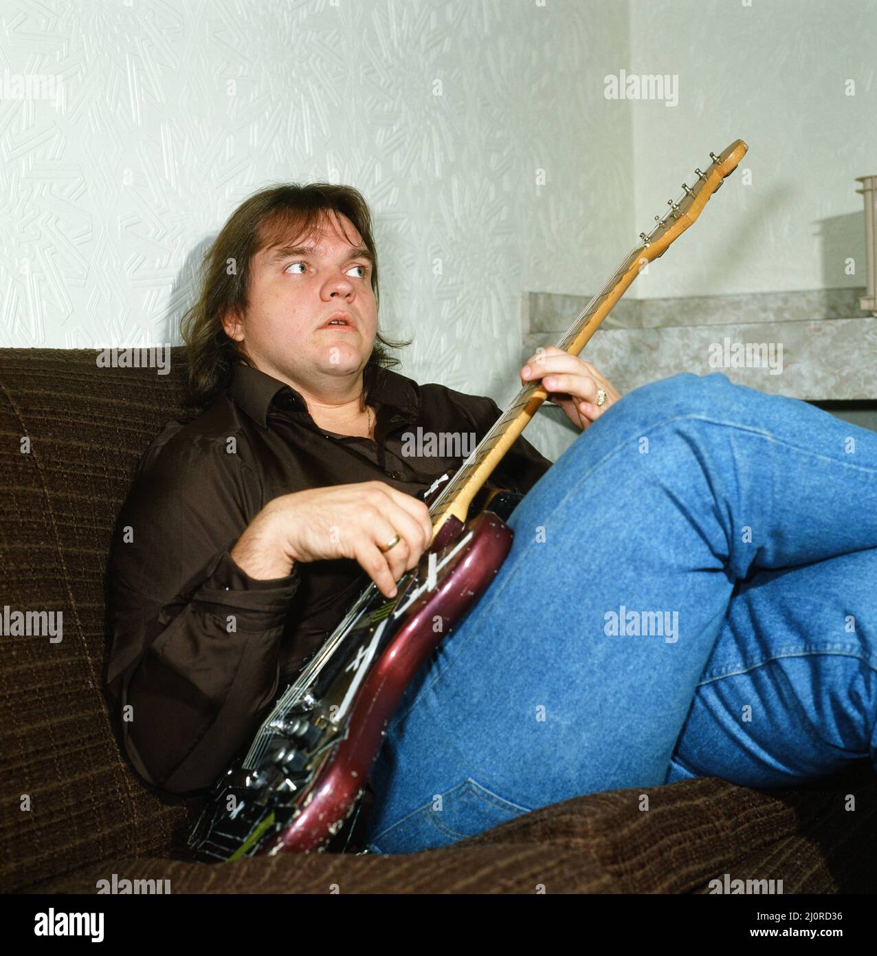 Musician Meat Loaf playing his guitar. September 1983 Stock Photo Alamy