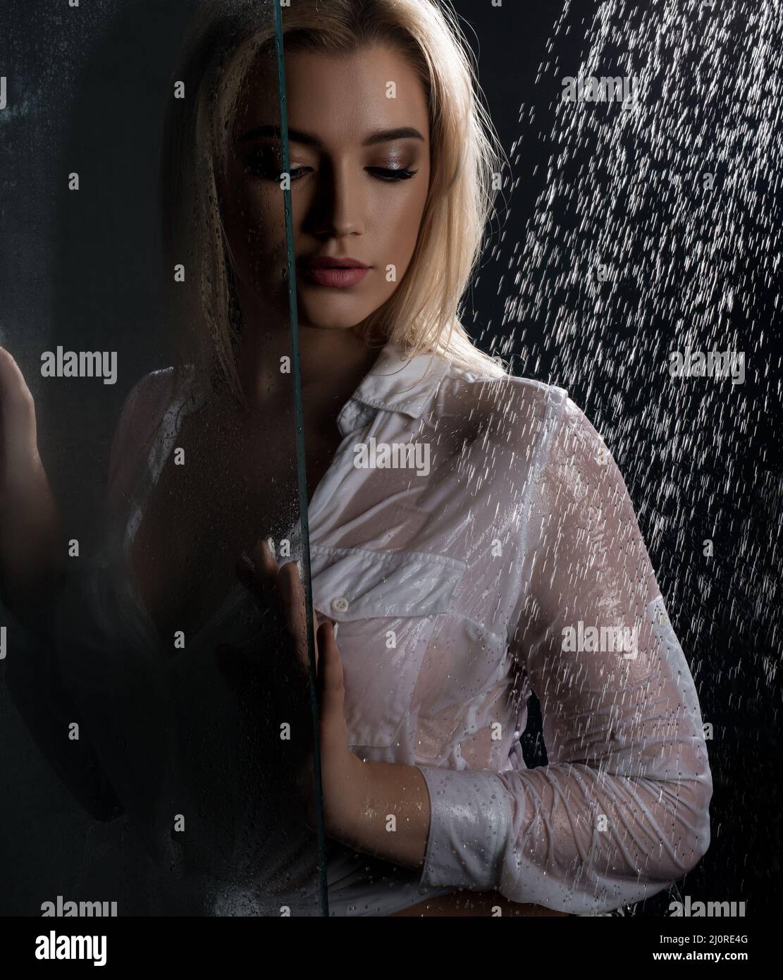 Pretty blonde in sexy shirt in shower Stock Photo