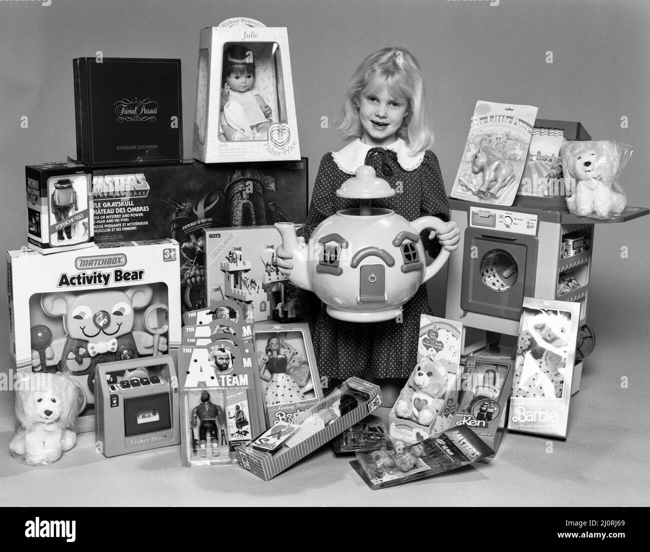 A young girl with a selection of children's toys for Christmas. 6th December 1984. Stock Photo