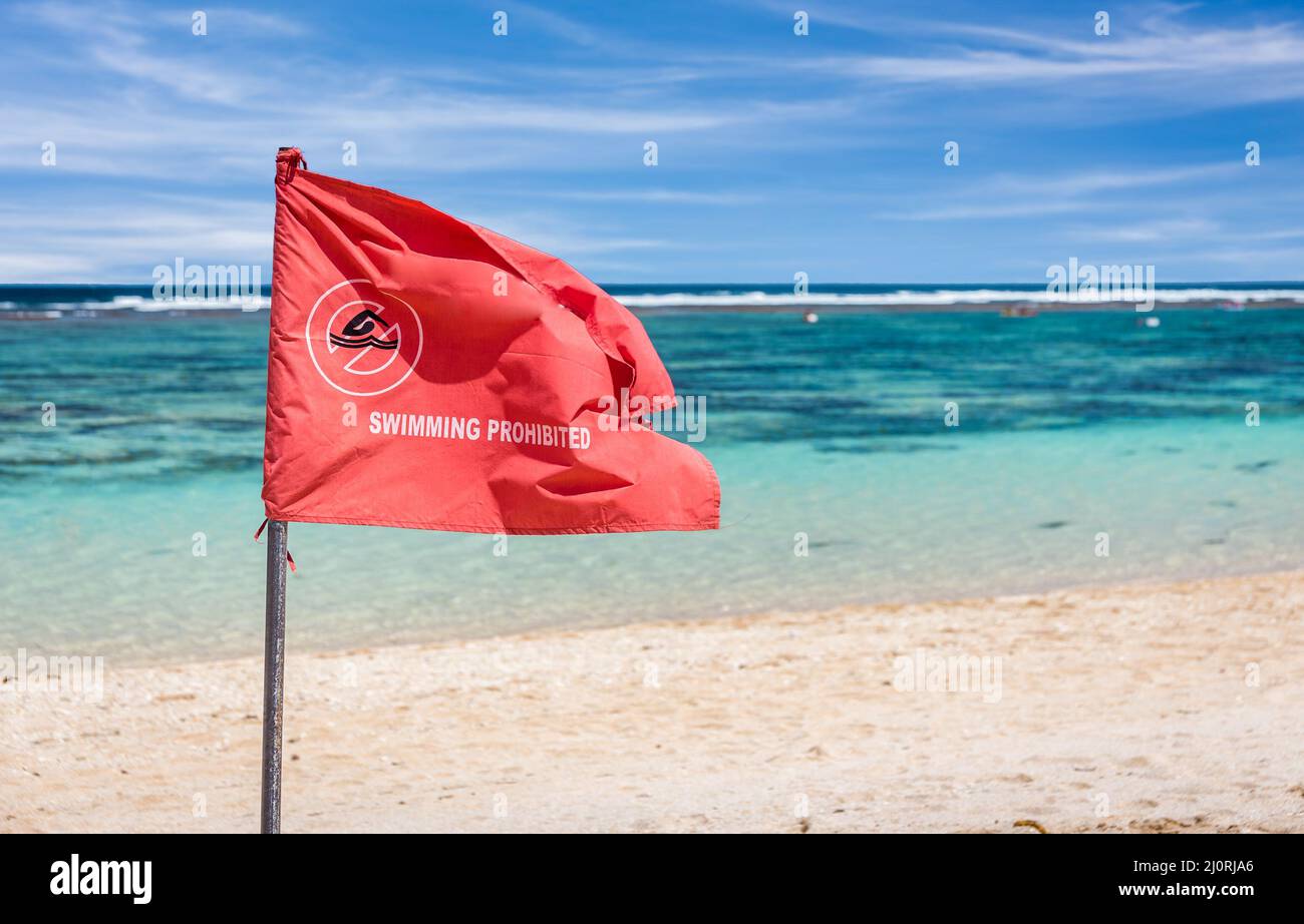 Red flag warning on sandy beach in Bali Stock Photo