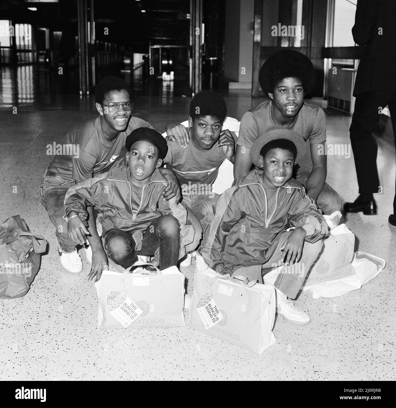 Musical Youth, British Jamaican pop / reggae group, who are flying out to Jamaica to film the video for their new single 'Never Ging to Give You Up'.   Pictured at London Heathrow Airport 31st January 1983.  Freddie Waite a.k.a. Junior 15, Dennis Seaton 15, Patrick Waite 14, Michael Grant 13 & Kelvin Grant 11 *** Local Caption *** Freddie Waite Junior Joir 15 Dennis Seaton 15 Patrick Waite 14 Michael Grant 13 Kelvin Grant 11 Stock Photo