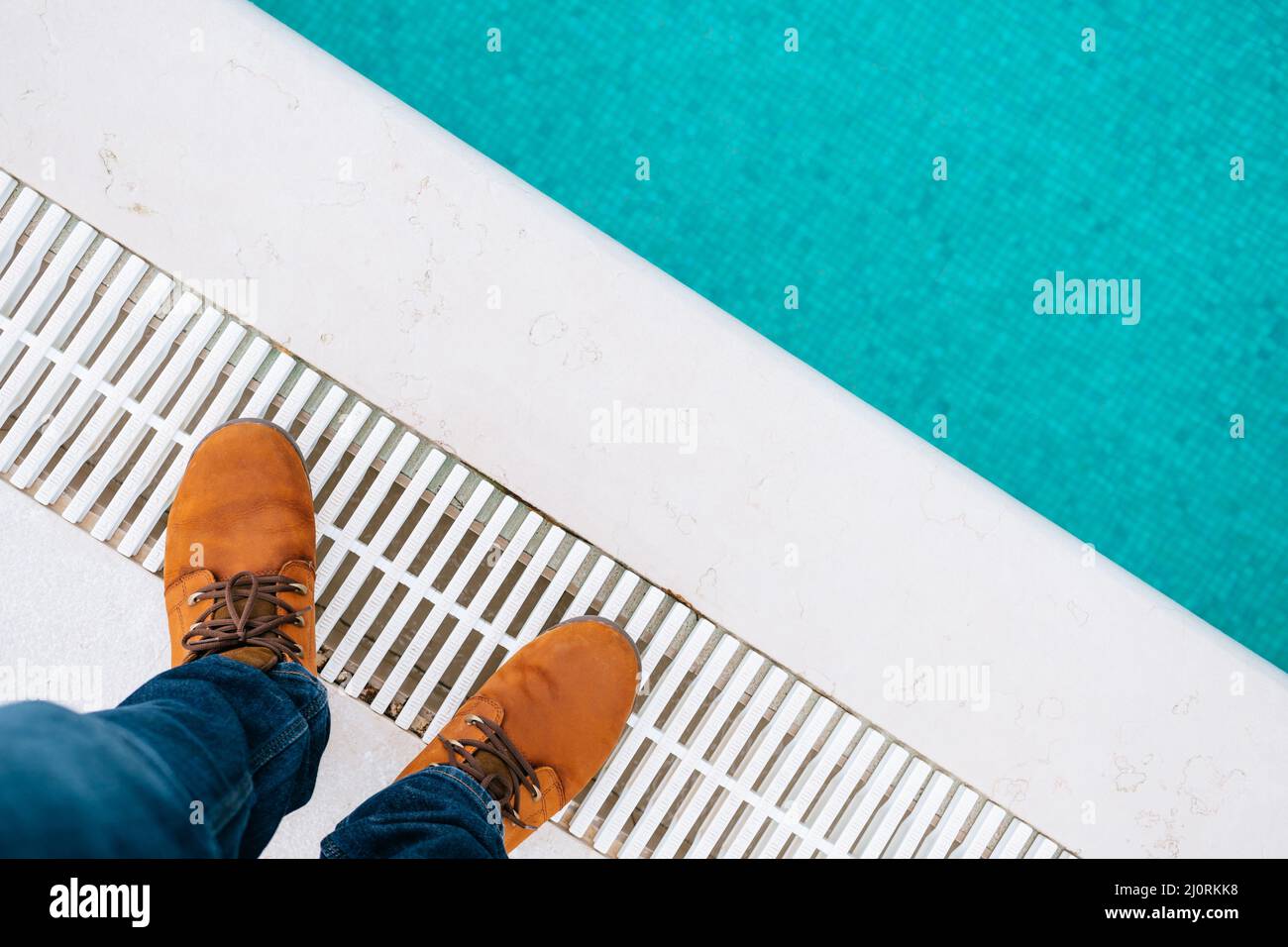 Male feet in brown boots and blue jeans stand at the edge of the pool. Closeup Stock Photo Alamy