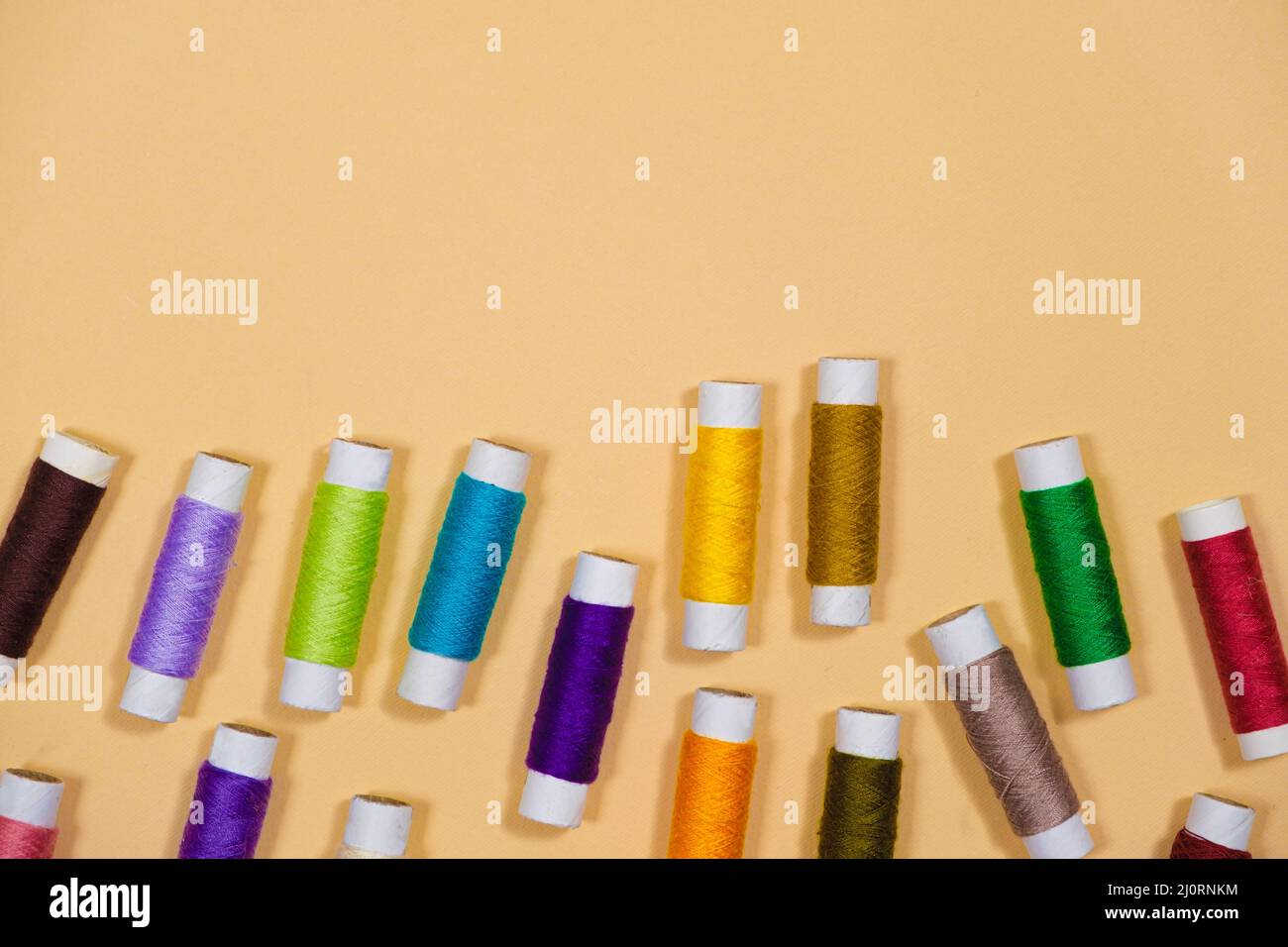 A set of multicolored threads for sewing with an empty space for text