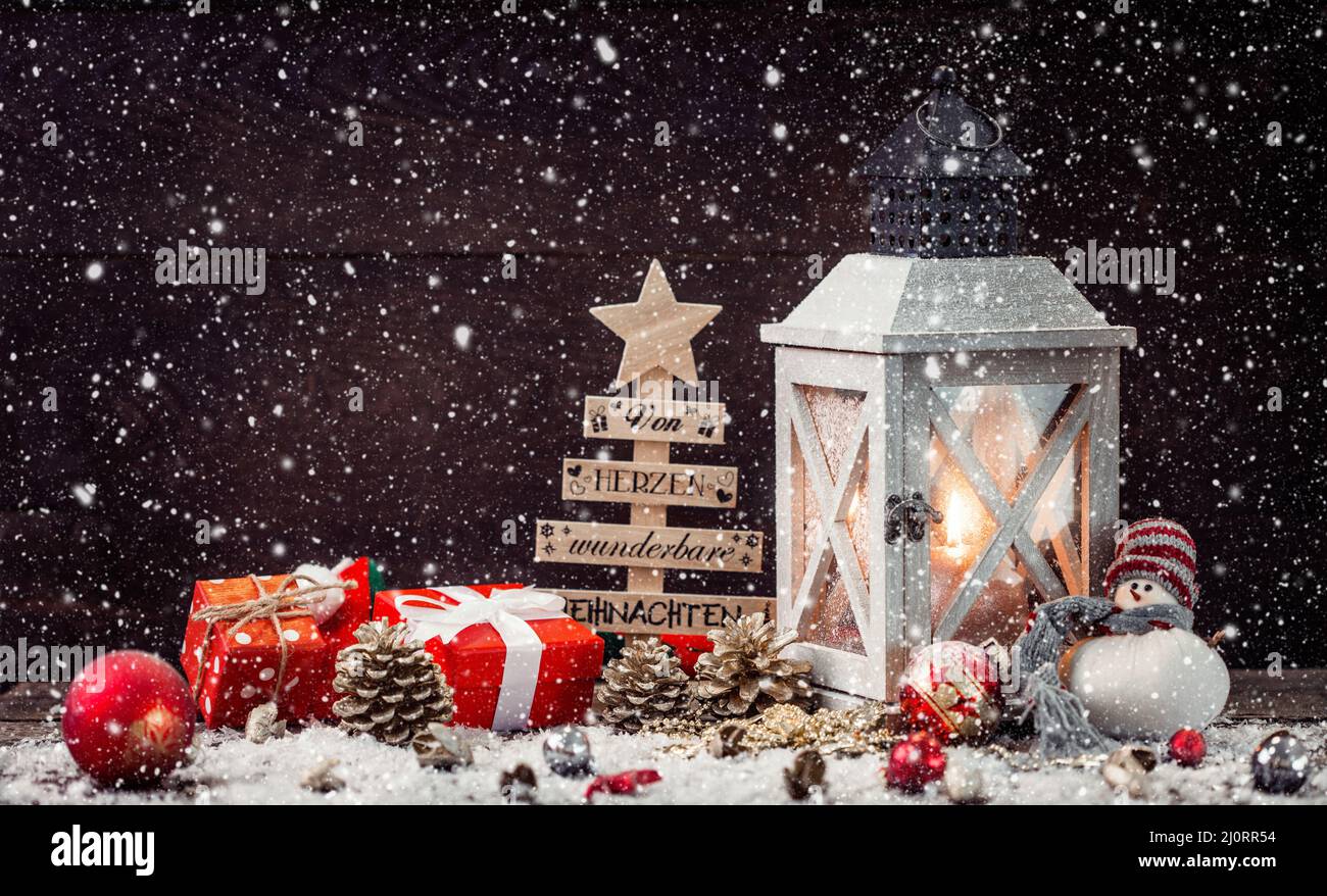 Christmas Lantern on snowy table with festive decoration. Stock Photo