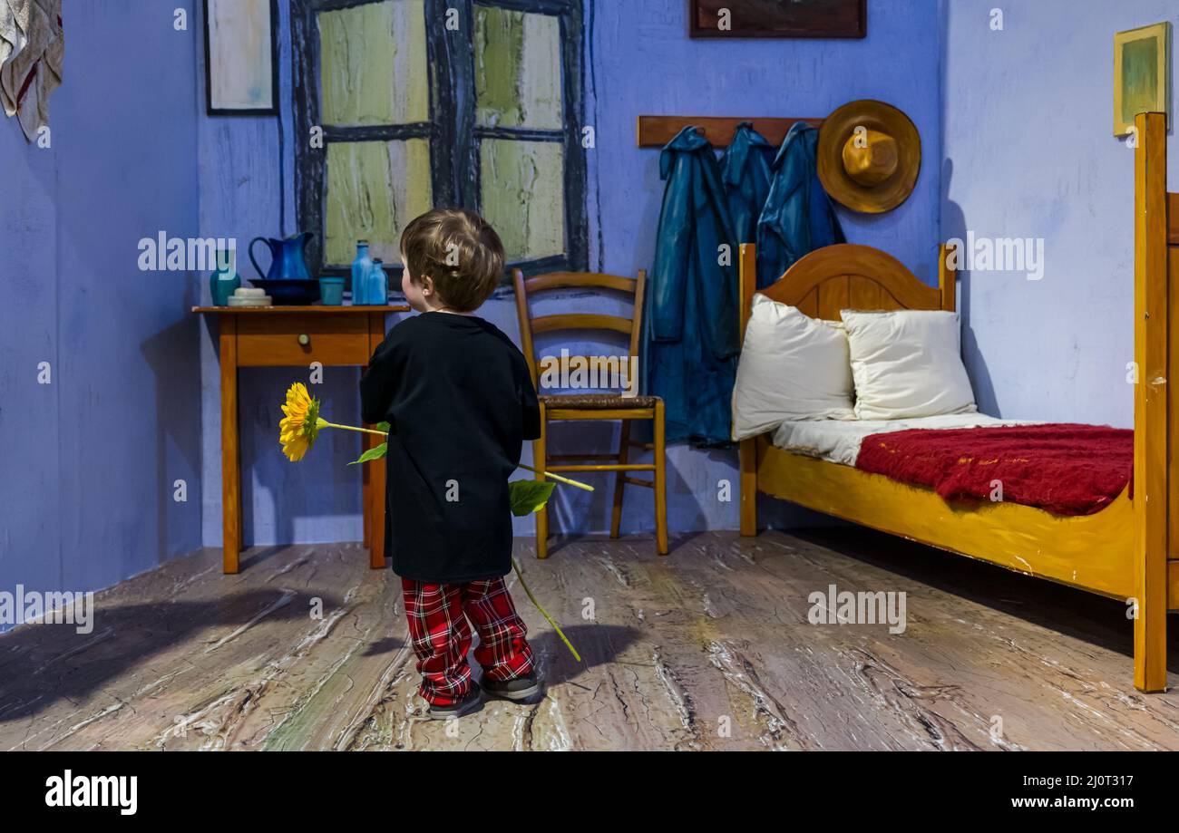 Young child with sunflowers in Room at Arles recreation at Van Gogh Alive art experience, Edinburgh, Scotland, UK Stock Photo