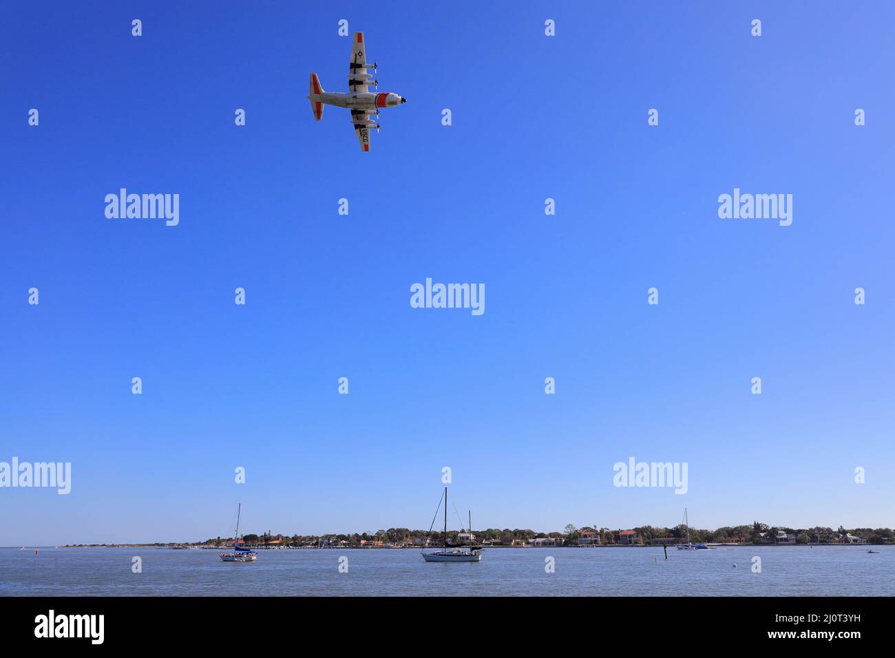 A US Coast Guard Lockheed C-130 Hercules airplane flying over the old town of Saint Augustine.Florida.USA Stock Photo