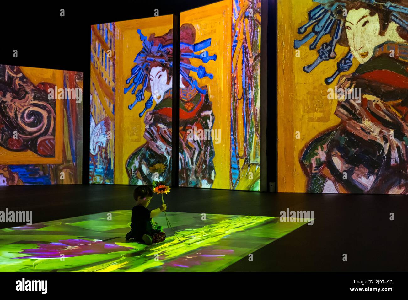 Young child holding sunflowers at Van Gogh Alive art exhibition and experience, Edinburgh