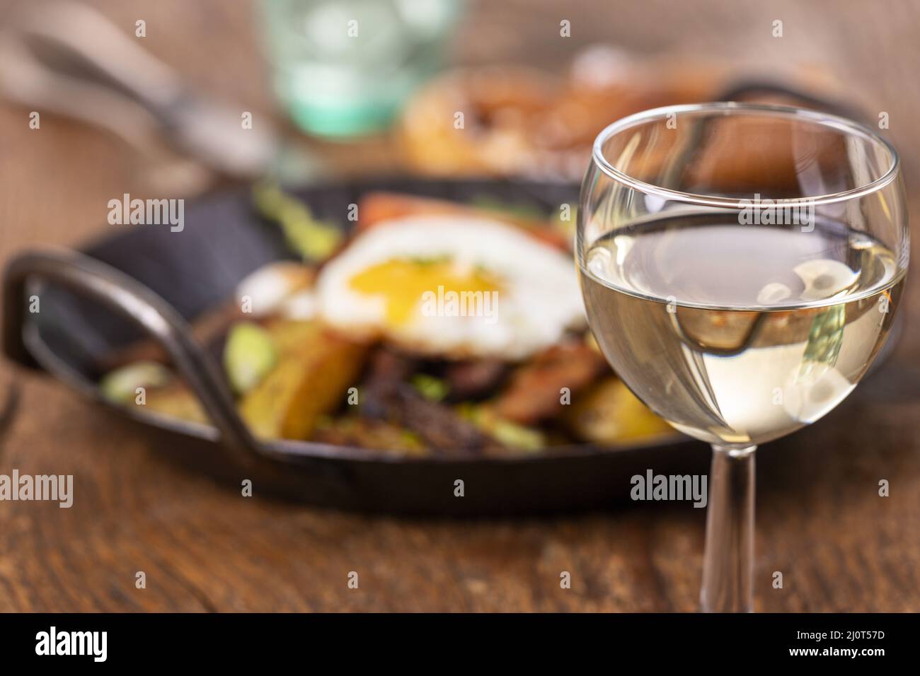 Wine and Tyrolean potato grÃ¶stlin the pan Stock Photo