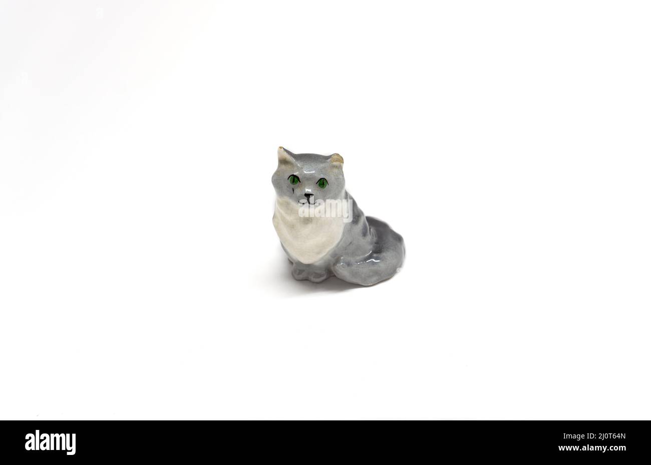 A smiling gray cat statuette isolated on a white background. Copy space. Stock Photo