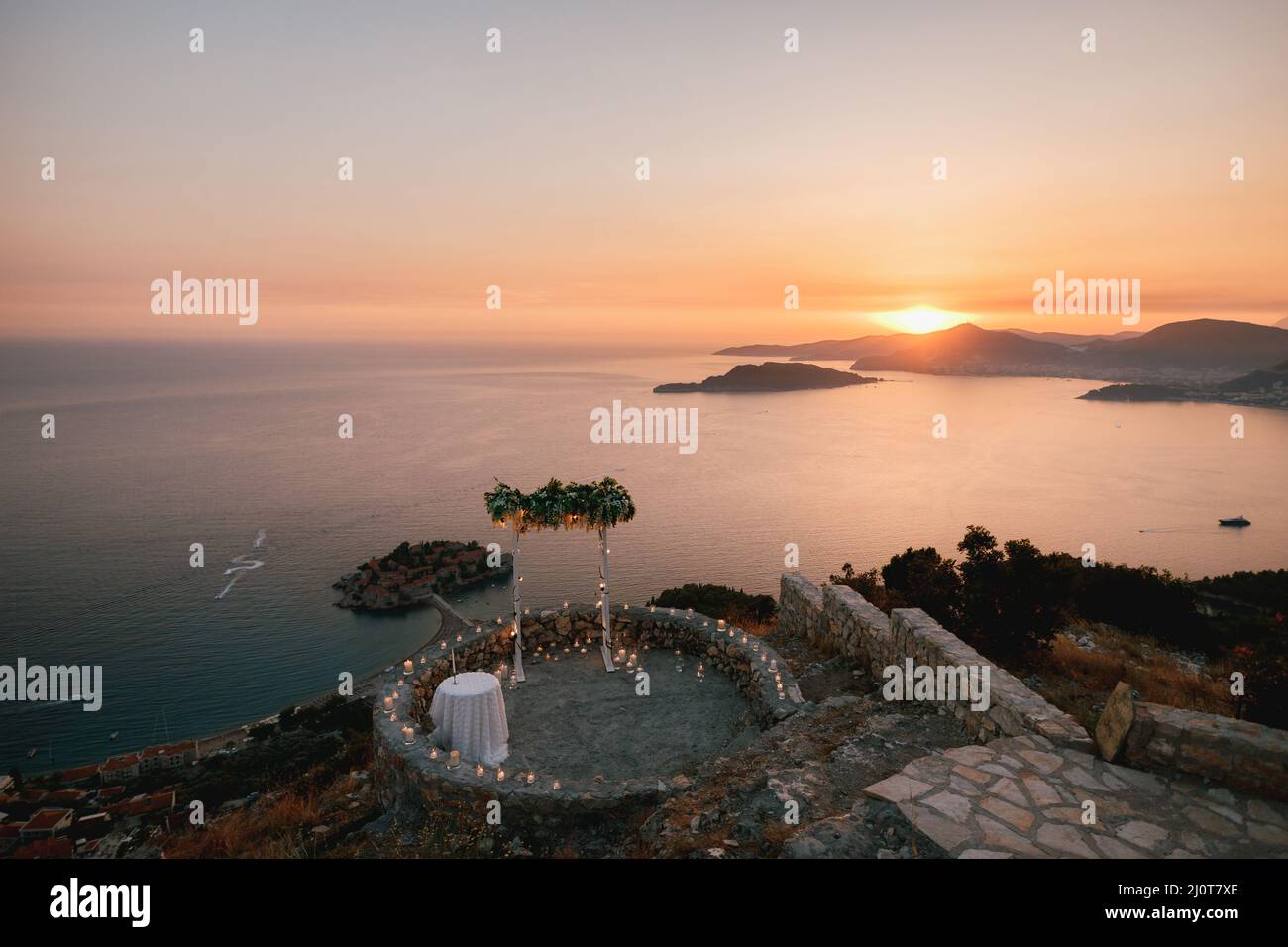 Wedding arch on the observation deck overlooking the island of Sveti Stefan at sunset Stock Photo
