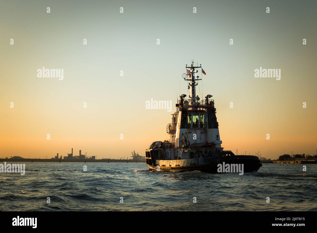 Tugboat at venice at sunset in front of industriel site of Marghera Stock Photo