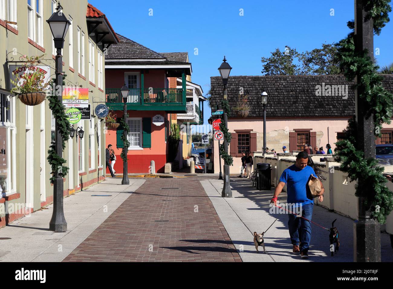 Lamp poles with Christmas decoration in Old Town of St.Augustine with man walk a dog.St.Augustine.Florida.USA Stock Photo