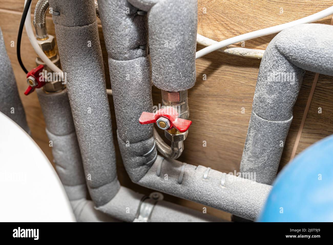 Closed water valves for equalizing the water pressure in a gas boiler in a modern home boiler room with ceramic tiles. Stock Photo