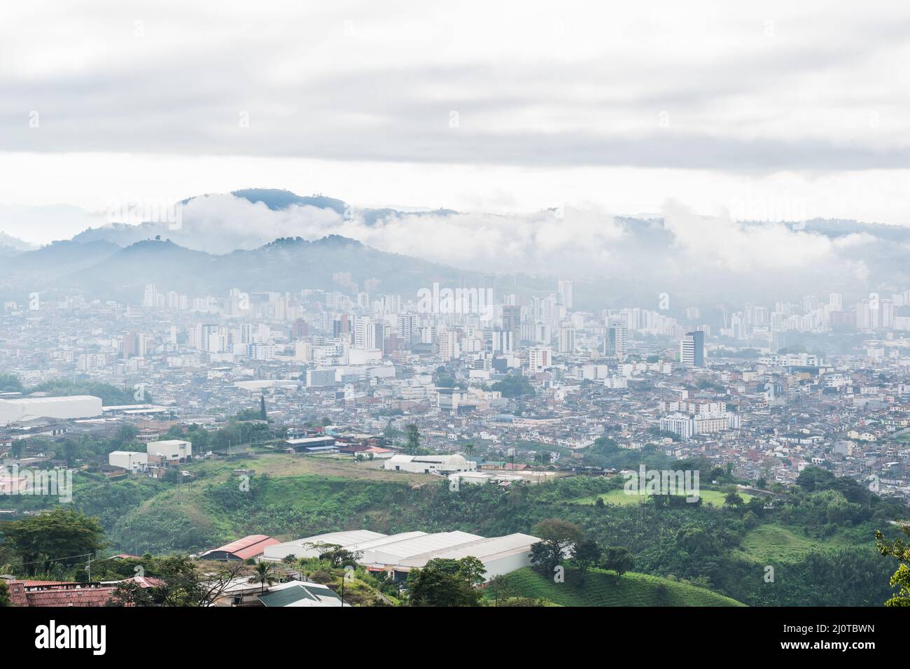panoramic view of the city of Pereira-Colombia seen from the top of a mountain in the hours of the cold cloudy morning and with a lot of fog around. Stock Photo