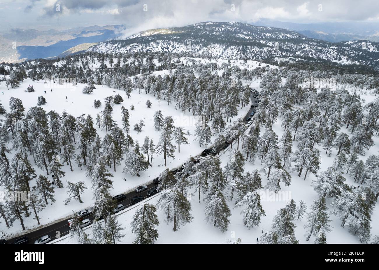 Drone aerial of highway road on the snowy forest mountain in winter. Stock Photo