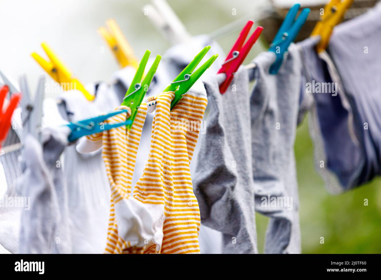 clothes streched with multicolor clamps on a green field Stock Photo