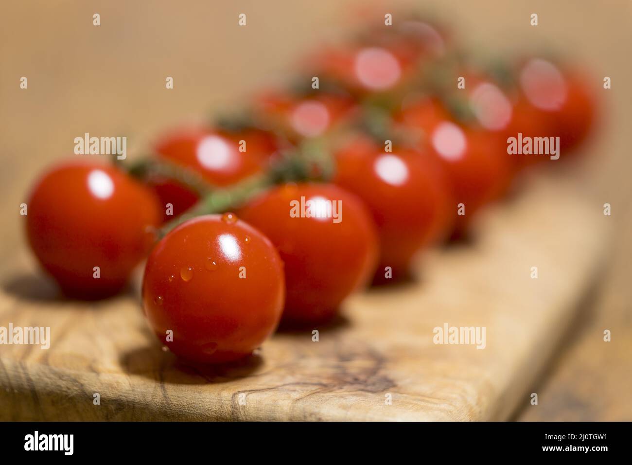 Row of raw tomatoes on wood Stock Photo