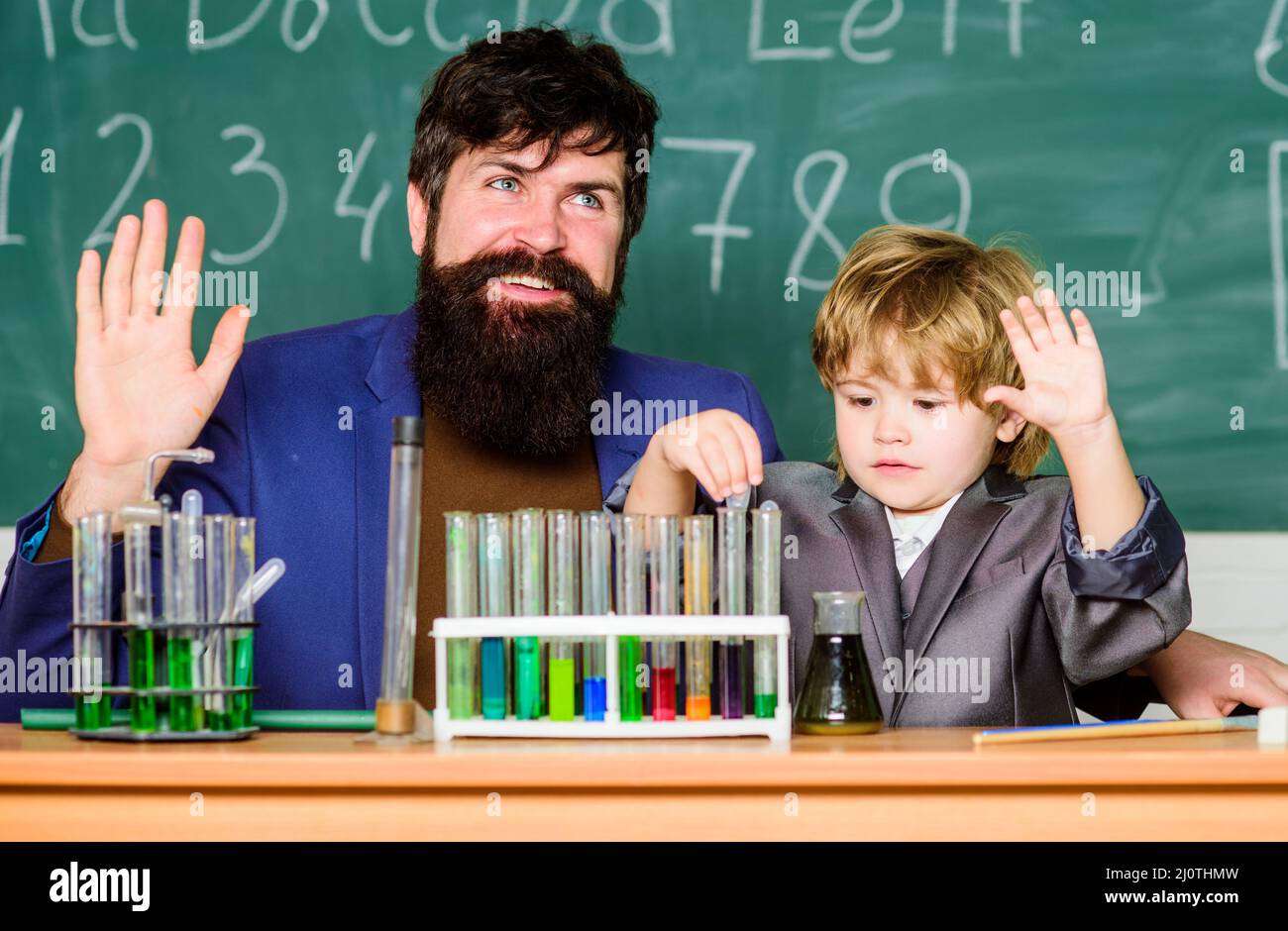 Teacher and child test tubes. Perseverance pays off. Chemical experiment. Symptoms of ADHD at school. Schoolboy cute child experimenting with liquids Stock Photo