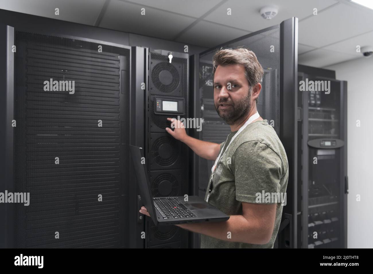 Data Center Engineer Using Laptop Computer Server Room Specialist Facility with Male System Administrator Working with Data Prot Stock Photo