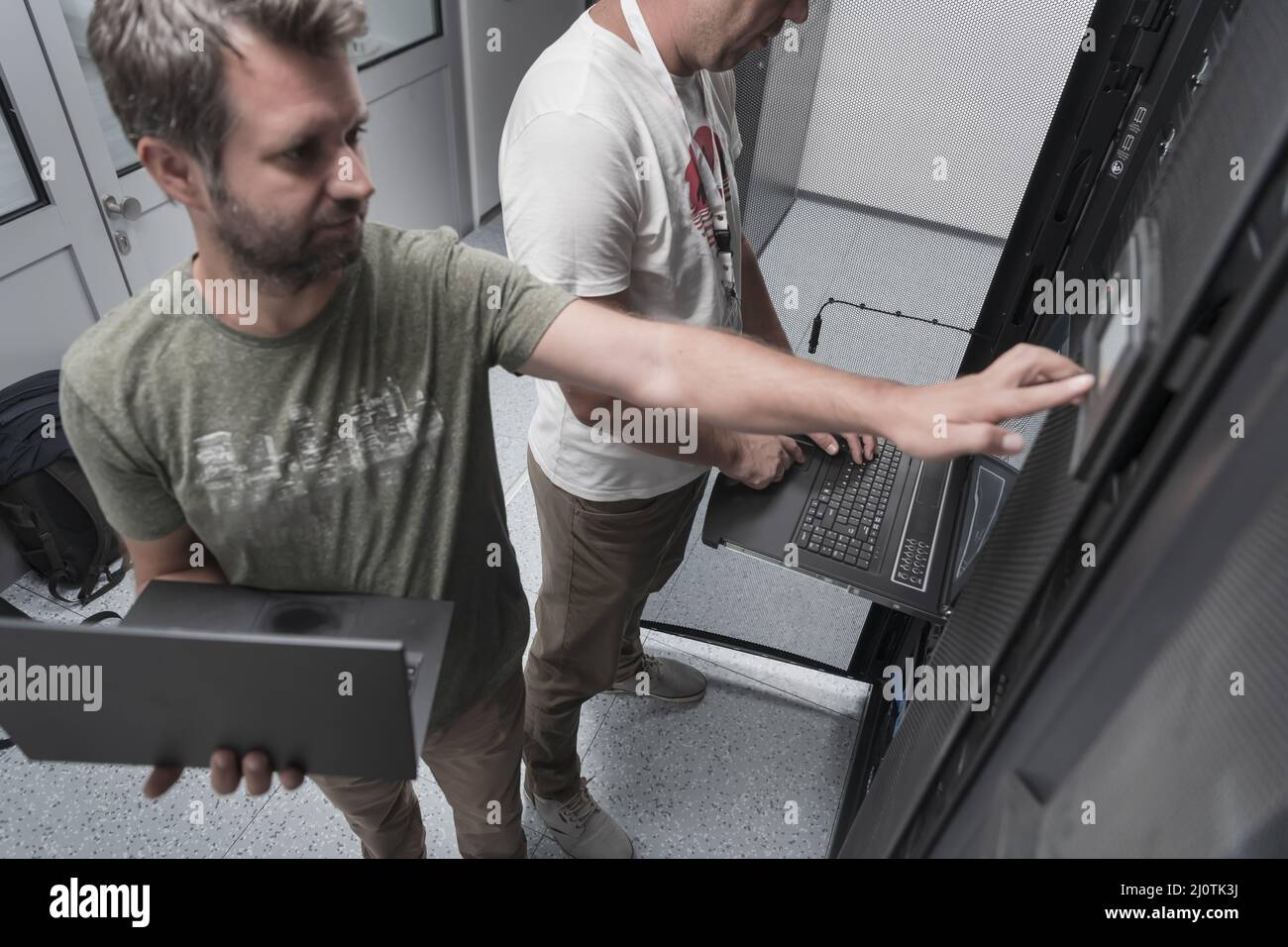 Technicians team updating hardware inspecting system performance in super  computer server room or cryptocurrency mining farm Stock Photo - Alamy