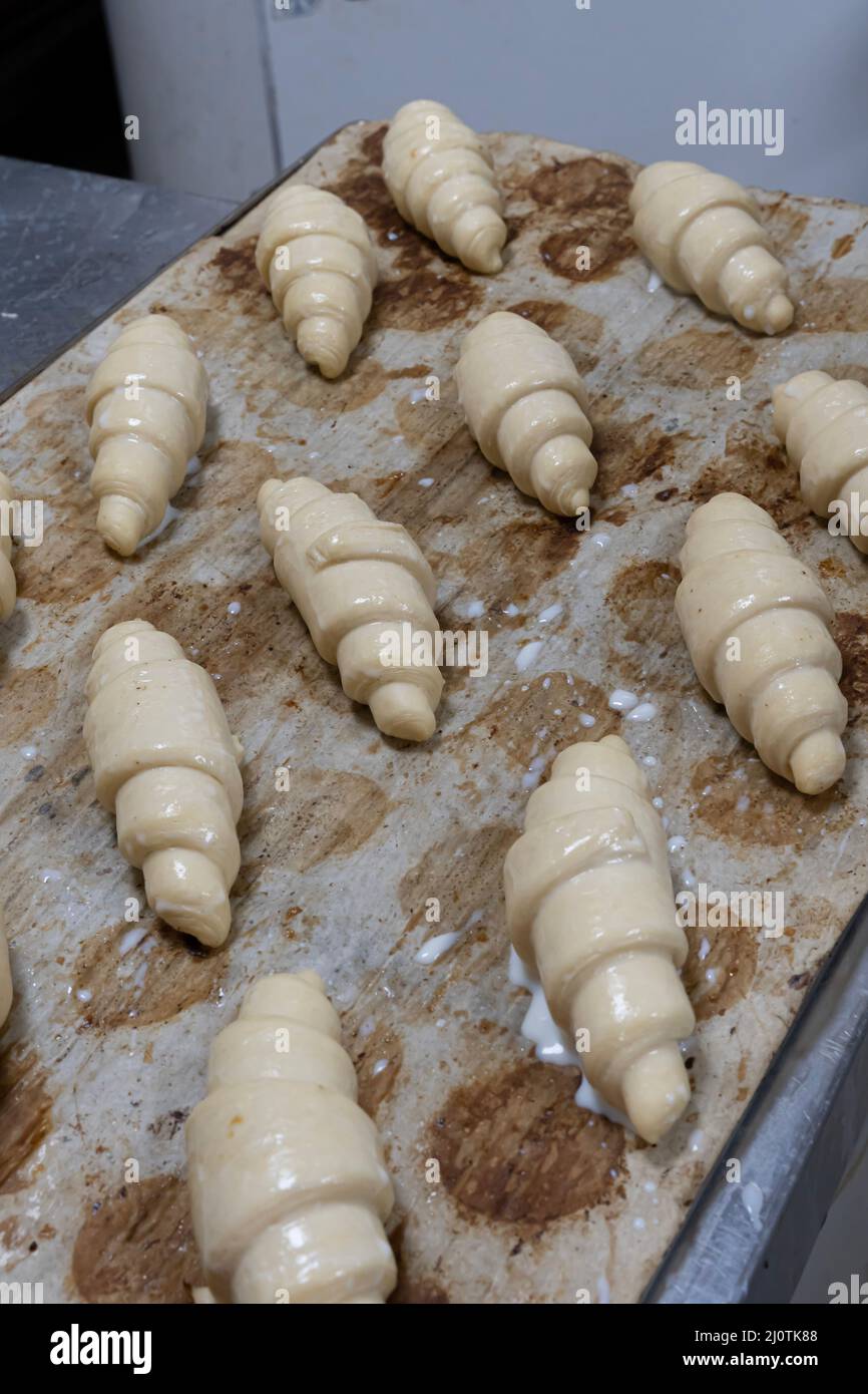 Artisan baker and pastry chef. Chef baker preparing croissants in a bakery Stock Photo