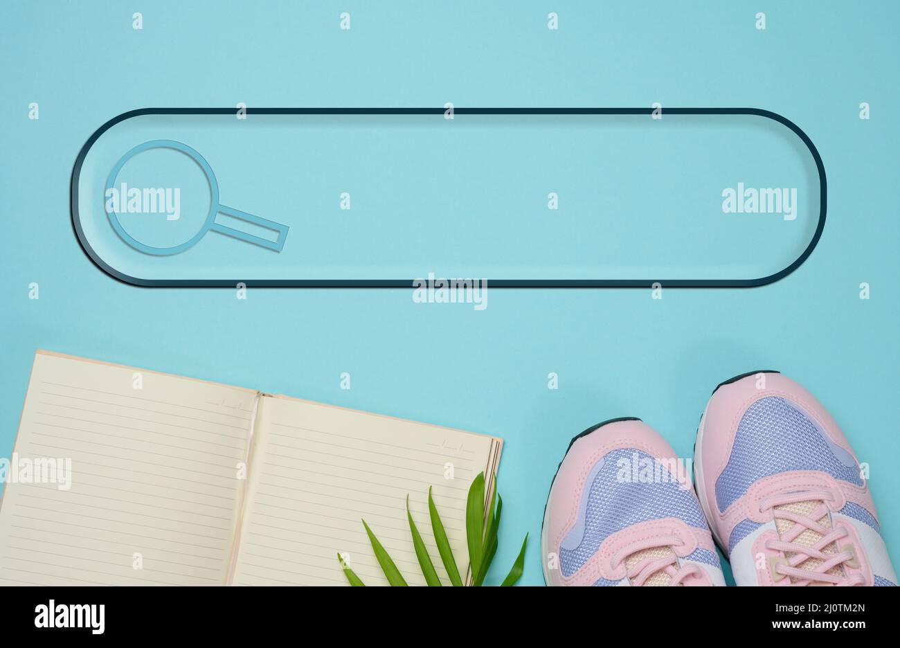 Pair of pink sneakers and open notebook on a blue background, sports. Copy space Stock Photo