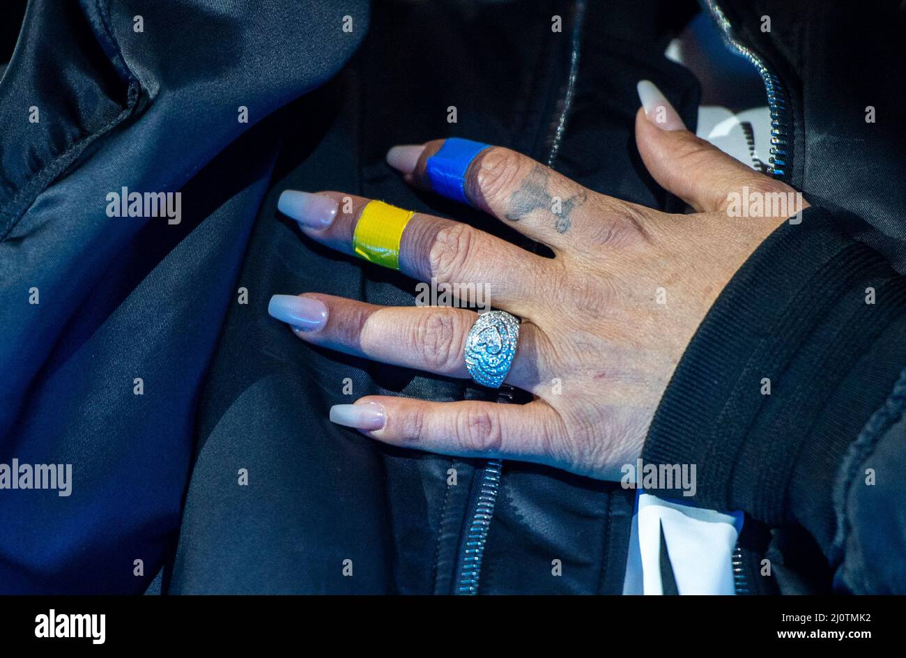 Berlin, Germany. 20th Mar, 2022. Sarah Connor sings on stage at the  solidarity rally "Sound of Peace" at the Brandenburg Gate and has tapes in  the Ukrainian national colors on her fingers .