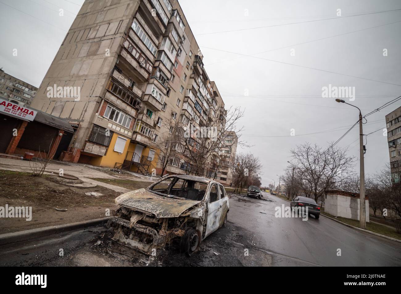 A block of apartment buildings and cars after the explosion of the Grad ...