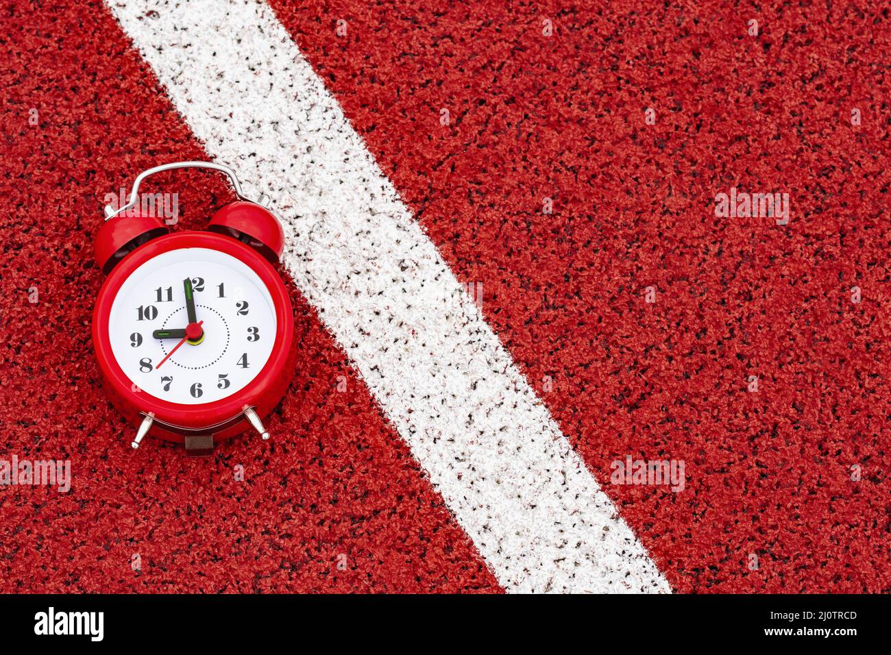 Alarm clock on the start line in sports stadium Stock Photo