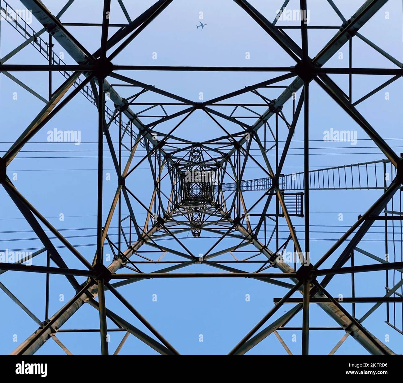 Low angle of a transmission tower under the blue sky Stock Photo - Alamy