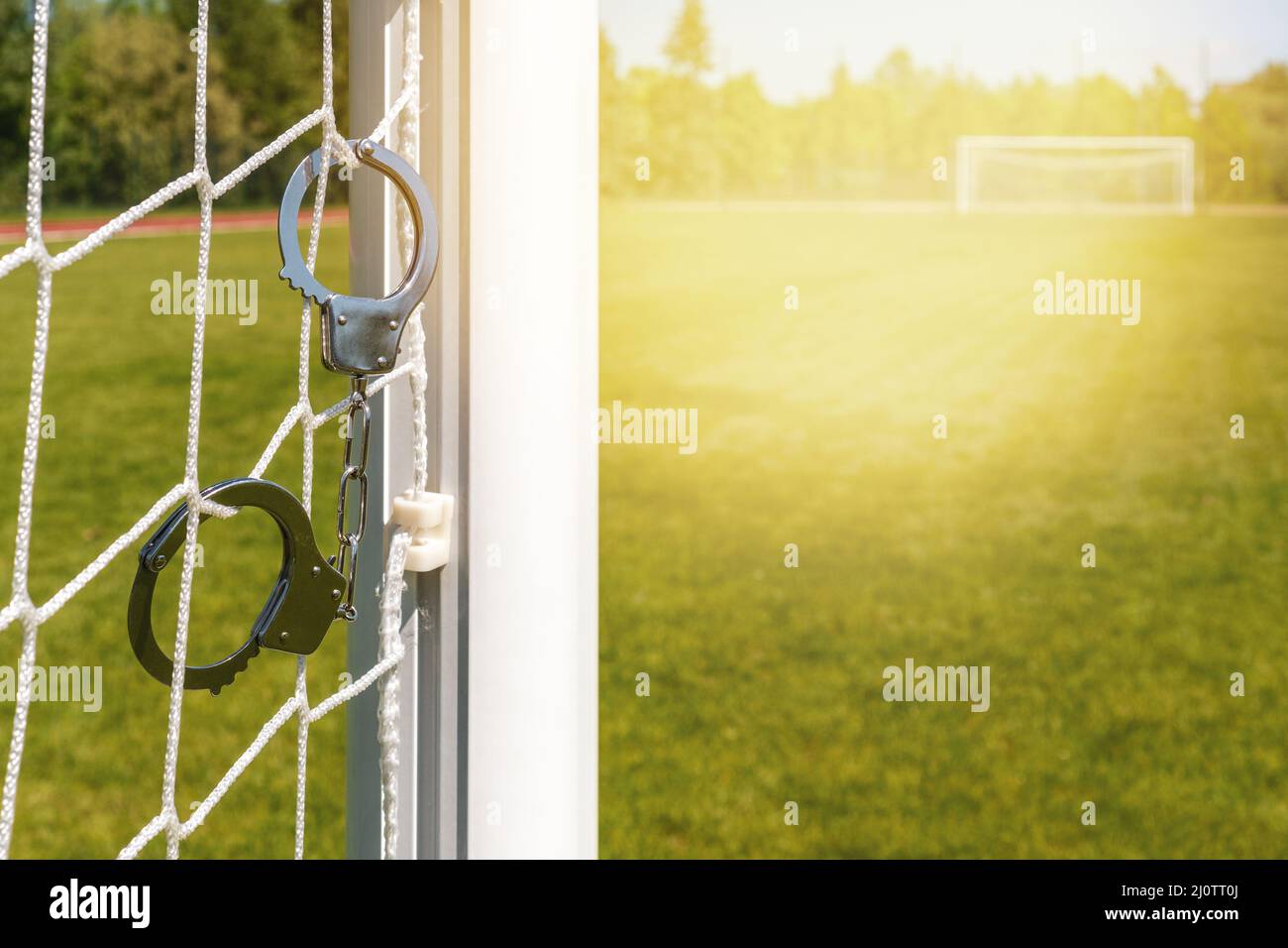Handcuffs hanging on the football goals Stock Photo