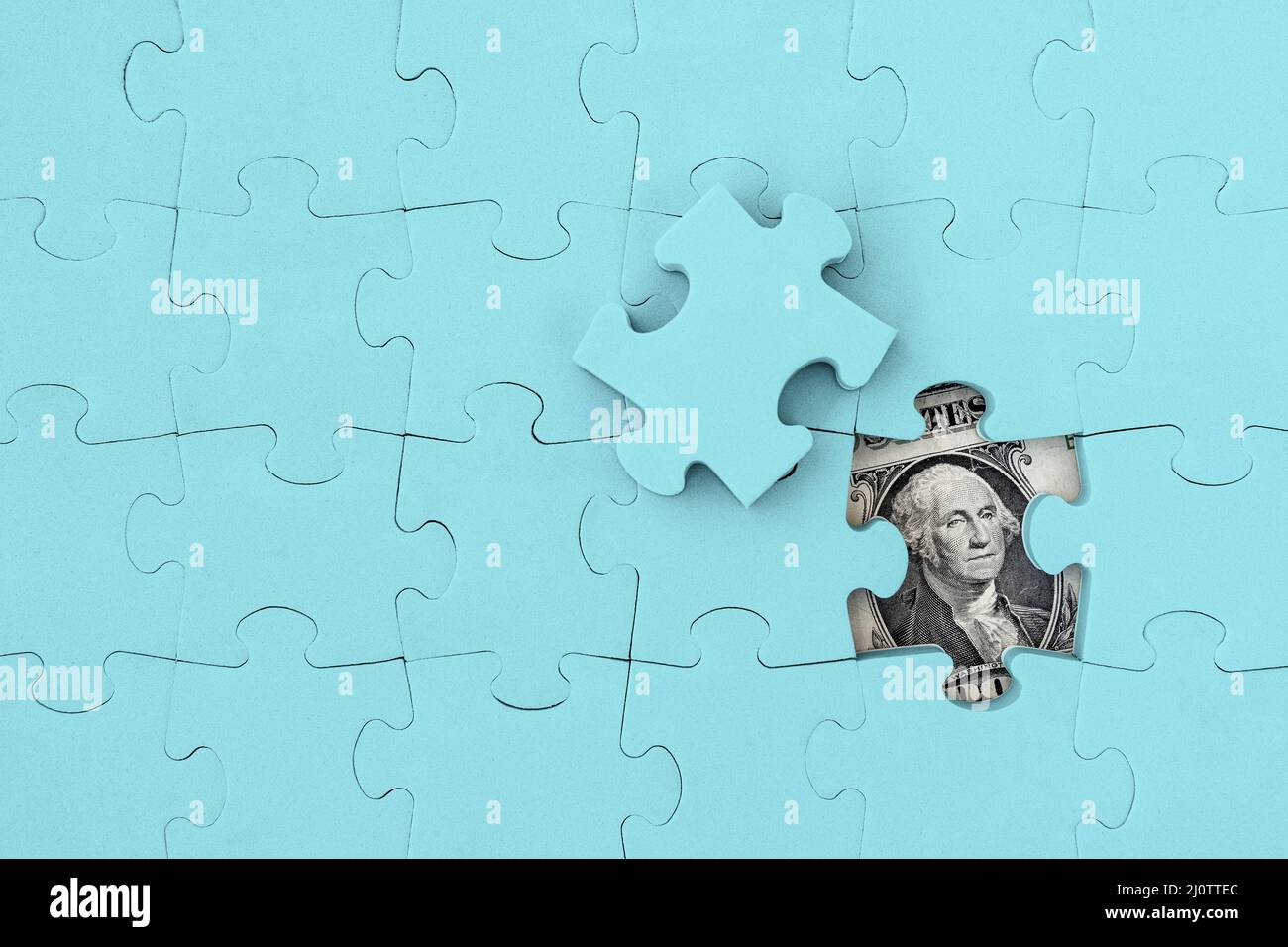 George Washington face from a one dollar bill between assembled puzzle pieces Stock Photo