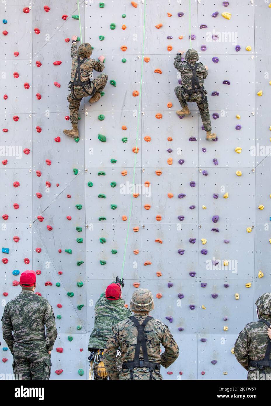 U.S. Marine Corps Cpl. Michael Clark, an inventory management specialist with 3D Sustainment Group (Experimental), 3D Marine Logistics Group, left, competes in a rock-climbing competition during a ropes course with U.S. Marine Corps Forces Korea and Republic of Korea Marine Corps Ranger School in Pohang, South Korea, Jan. 27, 2022. The course increased the Marines’ readiness with rappelling and rope work while improving interoperability with our partners and allies. (U.S. Marine Corps photo by Sgt. Ash McLaughlin) Stock Photo
